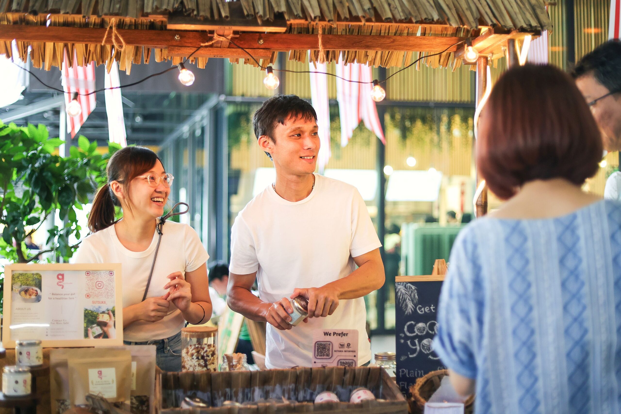 Wong and a team member at the Gutsuka market stall with plant-based yogurt displays